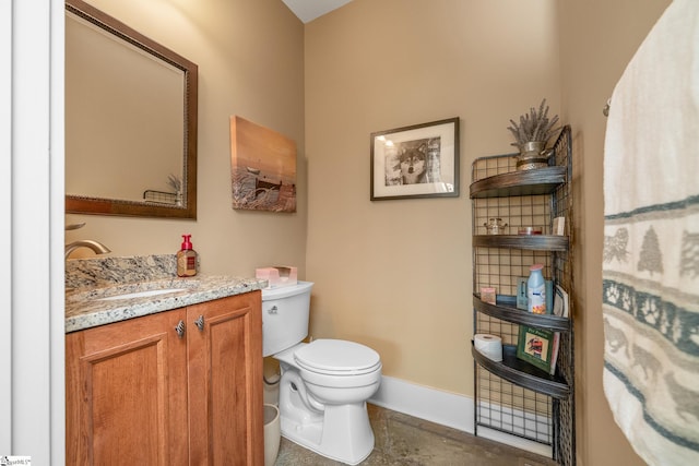 bathroom with vanity, baseboards, and toilet