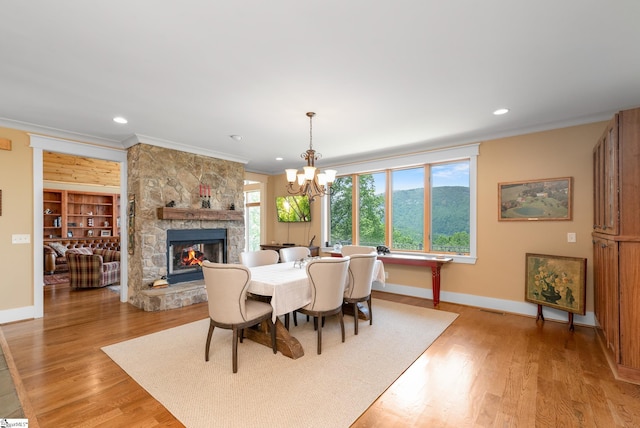 dining room featuring baseboards, recessed lighting, a fireplace, and light wood-type flooring