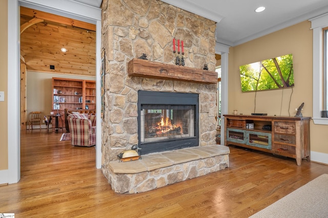 interior details featuring crown molding, a fireplace, recessed lighting, baseboards, and wood finished floors