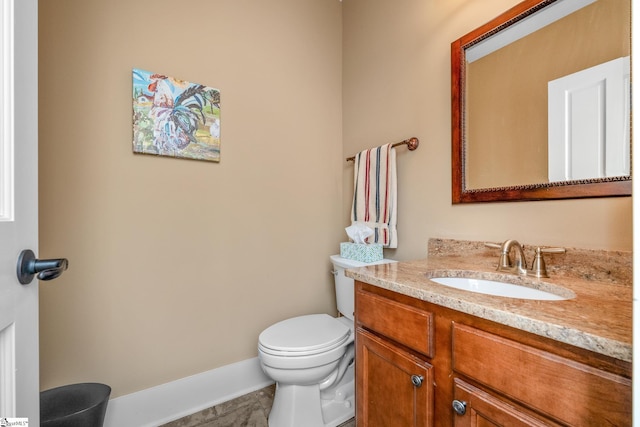bathroom with toilet, baseboards, and vanity