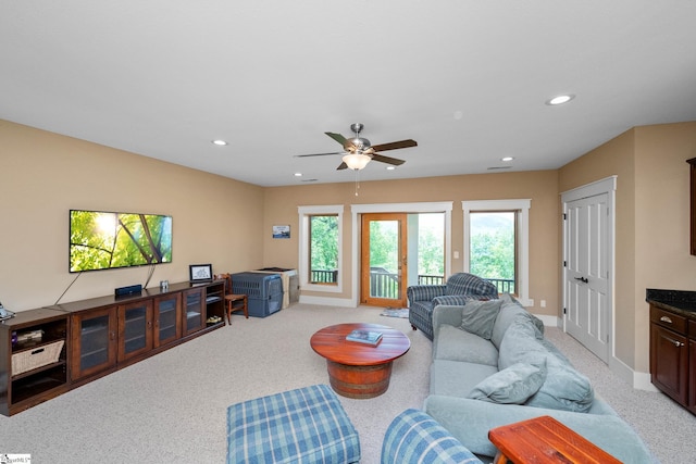 living area featuring baseboards, light carpet, a ceiling fan, and recessed lighting