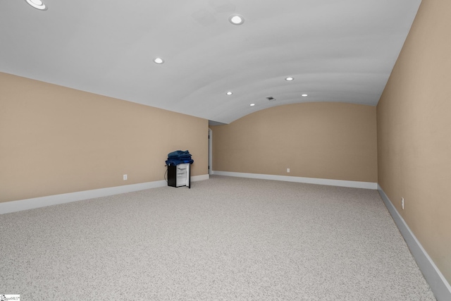 spare room with recessed lighting, baseboards, vaulted ceiling, and light colored carpet