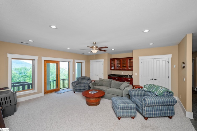 carpeted living area featuring baseboards, ceiling fan, recessed lighting, and visible vents