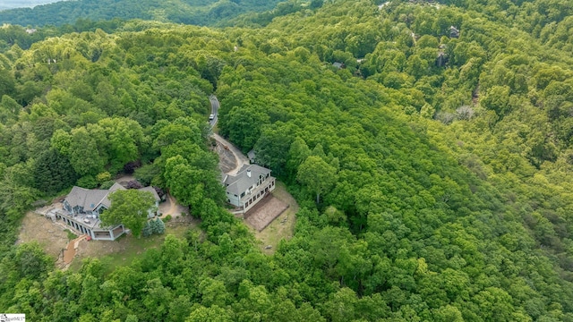 birds eye view of property featuring a forest view