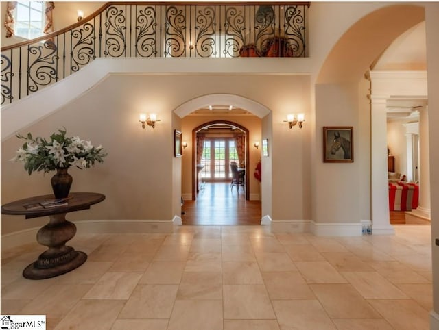 hall with stairs, arched walkways, and a high ceiling