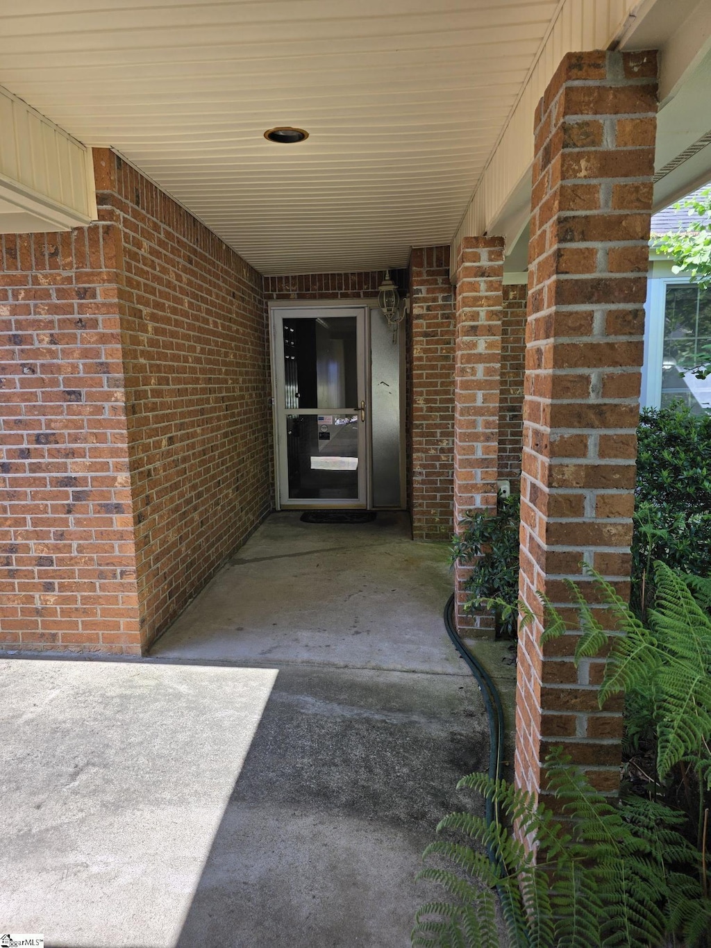 entrance to property featuring brick siding
