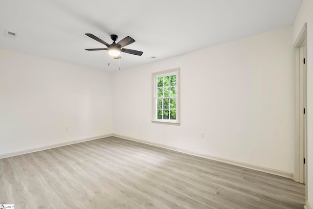 empty room with ceiling fan, visible vents, baseboards, and light wood-type flooring