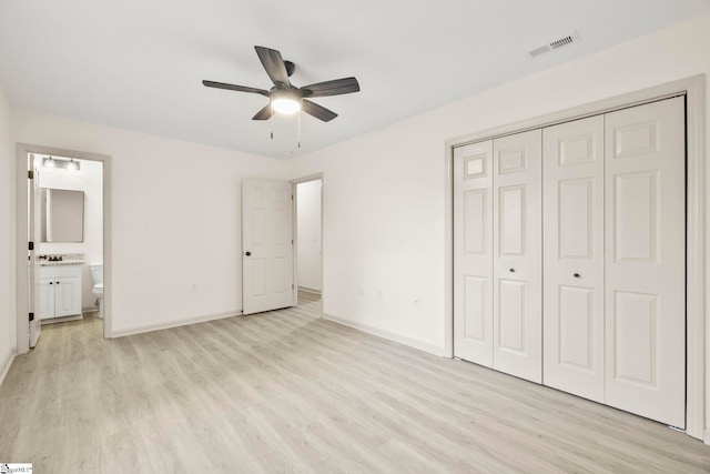 unfurnished bedroom with baseboards, a closet, light wood finished floors, and visible vents