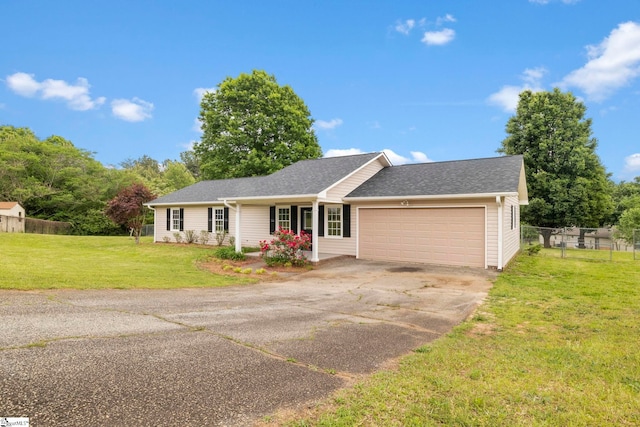 ranch-style home with fence, a front yard, roof with shingles, concrete driveway, and an attached garage