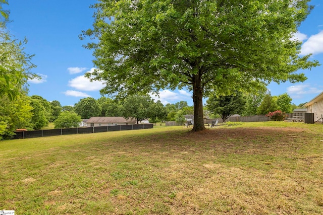 view of yard featuring fence and central AC