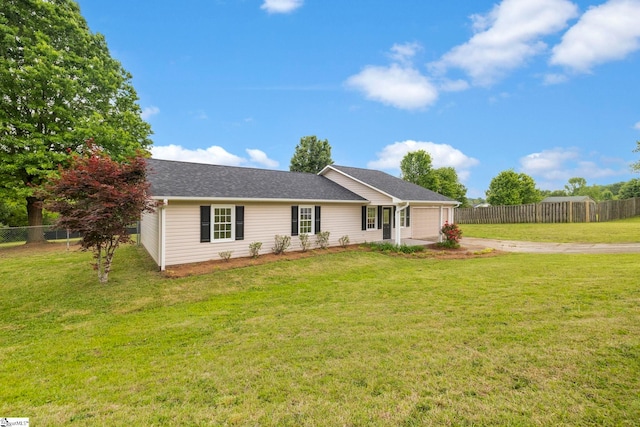 ranch-style home featuring a garage, a front lawn, fence, and driveway