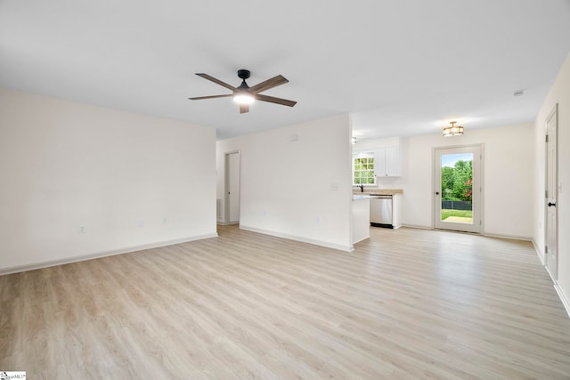 unfurnished living room with light wood-style floors, a ceiling fan, and baseboards