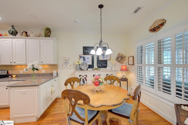 132 Hartsfield Dr, Easley, SC 29642 - dining area with crown molding, an inviting chandelier, light wood-style flooring, baseboards, and visible vents