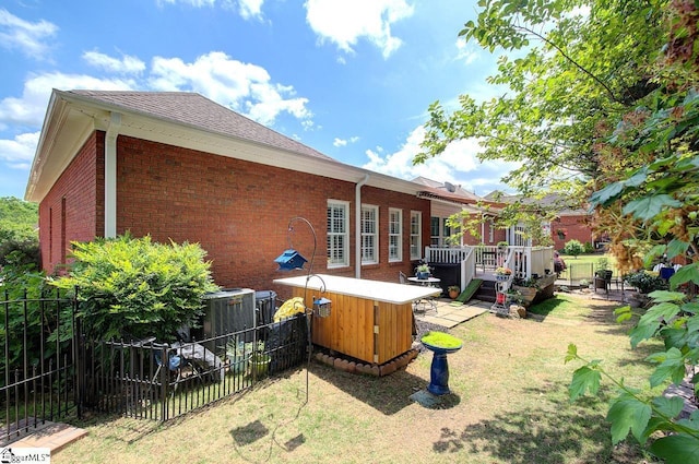 132 Hartsfield Dr, Easley, SC 29642 - rear view of house featuring a lawn, a wooden deck, brick siding, fence, and a jacuzzi