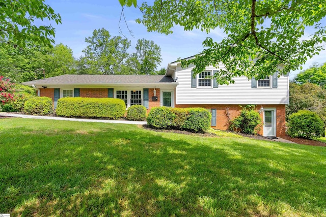 split level home featuring brick siding and a front yard