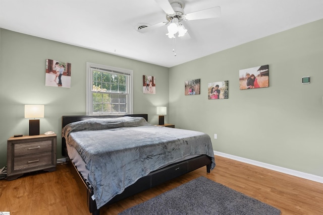 bedroom with baseboards, ceiling fan, and wood finished floors