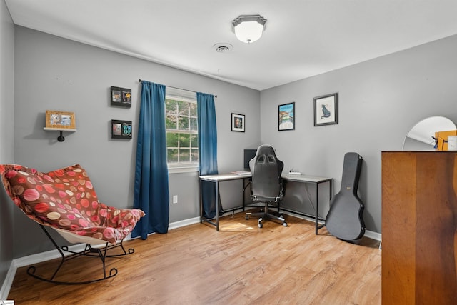 home office with baseboards, visible vents, and wood finished floors