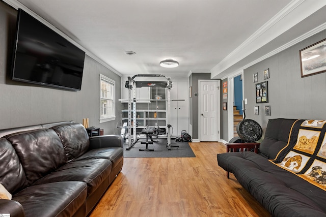 living area featuring crown molding, wood finished floors, visible vents, and stairway