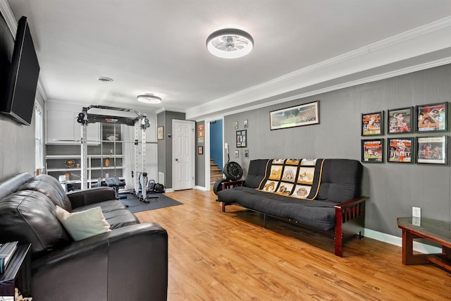 living area with light wood-type flooring, ornamental molding, and baseboards