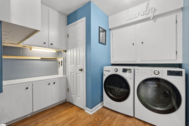 laundry room featuring baseboards, light wood-style flooring, cabinet space, and washing machine and dryer