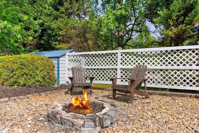 view of yard with an outbuilding, a storage unit, and an outdoor fire pit