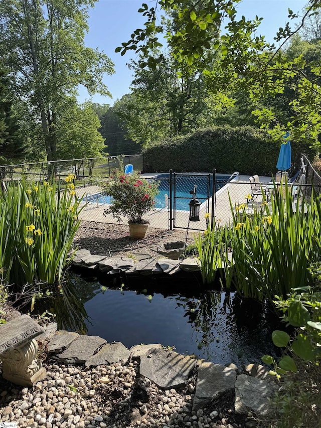 view of swimming pool featuring fence and a fenced in pool