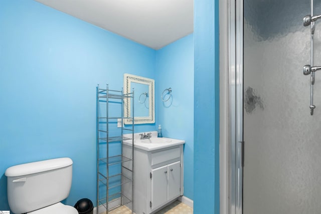 bathroom with vanity, toilet, and a stall shower
