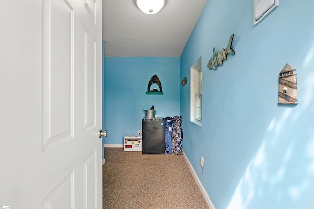 hallway featuring baseboards and carpet floors