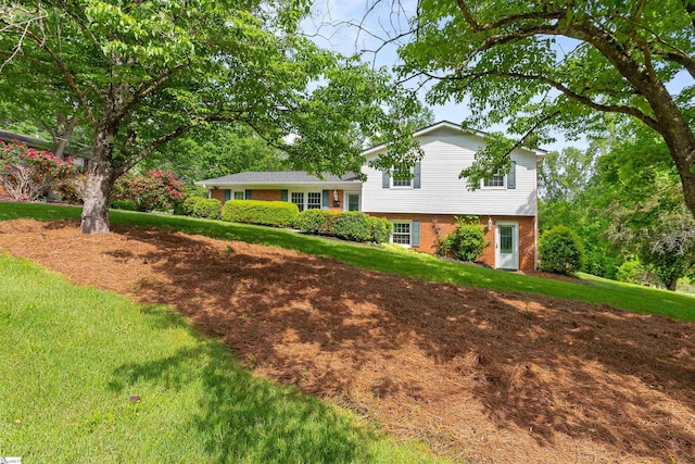 split level home featuring brick siding and a front yard