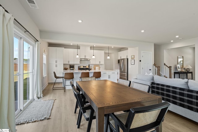 dining room with light wood-style floors, recessed lighting, and visible vents