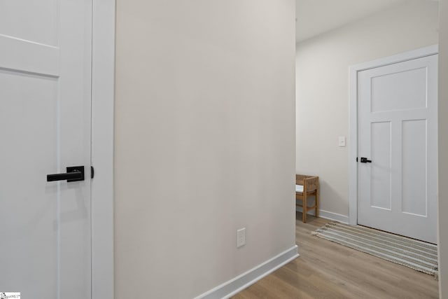 hall featuring baseboards and wood finished floors
