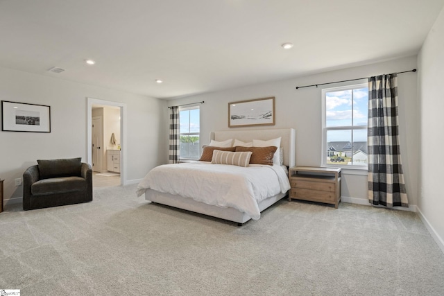 bedroom with recessed lighting, baseboards, light carpet, and ensuite bathroom