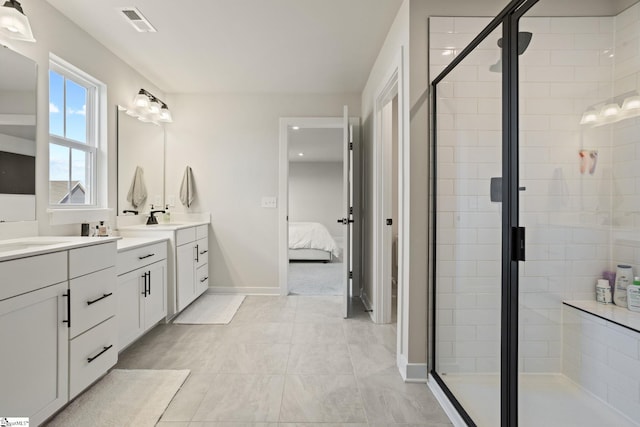 bathroom featuring vanity, baseboards, visible vents, and a stall shower