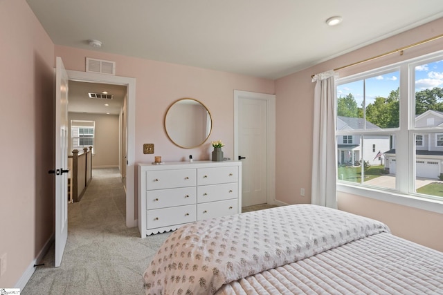 bedroom with baseboards, light carpet, and visible vents