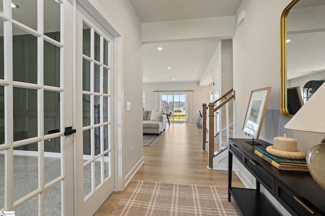 corridor featuring recessed lighting, baseboards, stairs, and wood finished floors