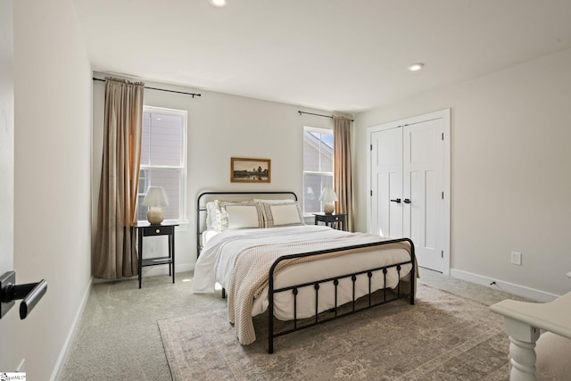 carpeted bedroom with baseboards, a closet, and recessed lighting