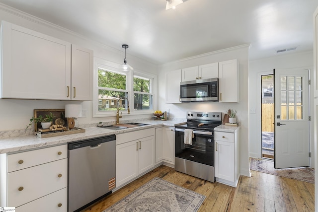 kitchen with visible vents, white cabinets, a sink, light wood-style flooring, and stainless steel appliances