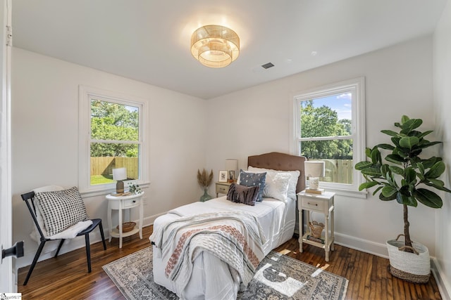bedroom featuring baseboards, dark wood-style flooring, and visible vents