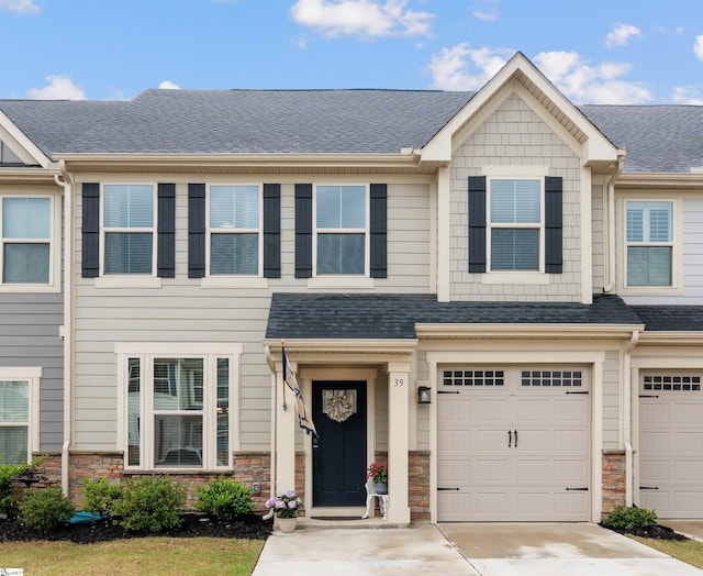 multi unit property with a shingled roof, an attached garage, driveway, and stone siding