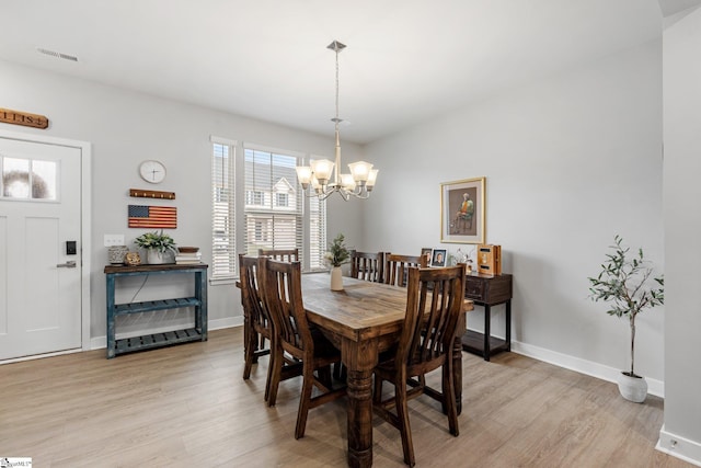 dining room with baseboards, visible vents, light wood-type flooring, and a chandelier