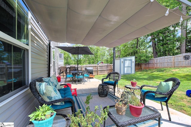 view of patio with outdoor dining area, a fenced backyard, an outbuilding, and a storage shed