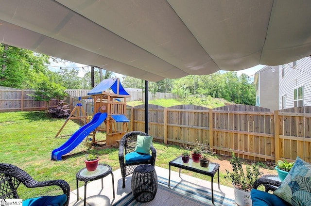 view of playground with a lawn and a fenced backyard