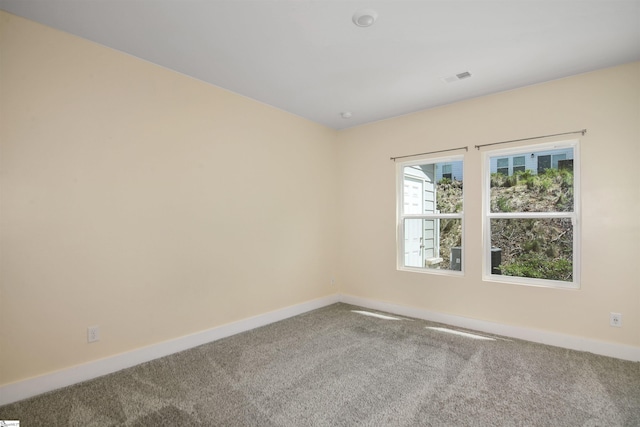 unfurnished room with baseboards, carpet, and visible vents