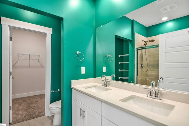 bathroom with toilet, tile patterned floors, a shower stall, and a sink