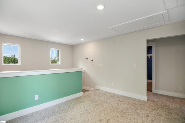 carpeted spare room with recessed lighting, baseboards, and attic access