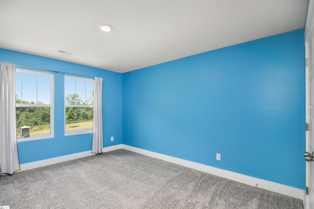 carpeted spare room with baseboards and visible vents