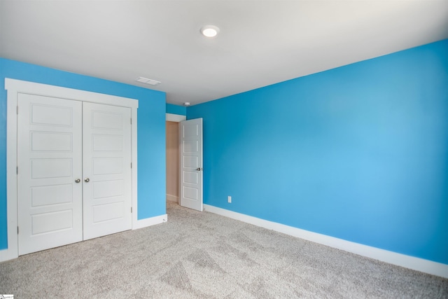 unfurnished bedroom with carpet floors, baseboards, a closet, and visible vents