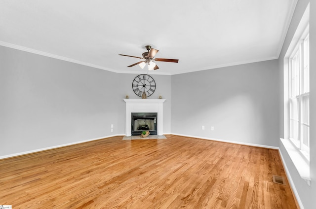 unfurnished living room featuring a ceiling fan, baseboards, a fireplace with flush hearth, light wood-type flooring, and visible vents
