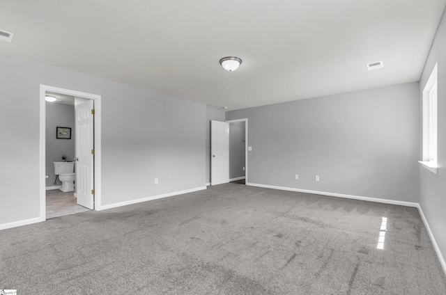 unfurnished bedroom with carpet floors, baseboards, connected bathroom, and visible vents