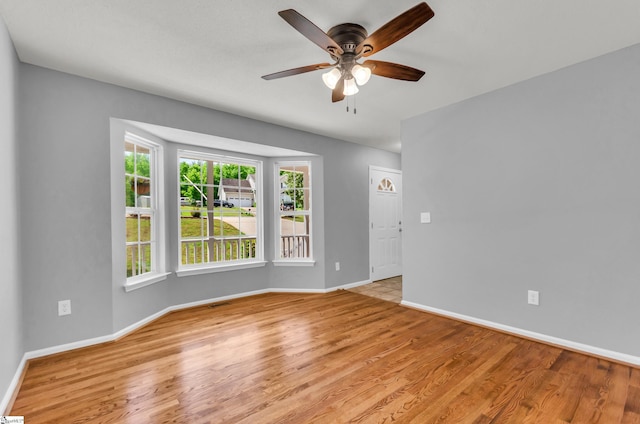 unfurnished room featuring baseboards, light wood finished floors, and ceiling fan